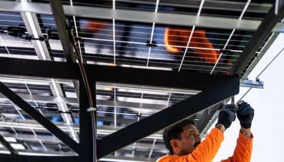 Technician installing solar panels on a mounting structure