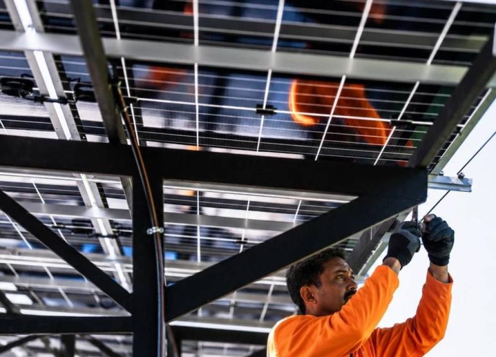 Technician installing solar panels on a mounting structure